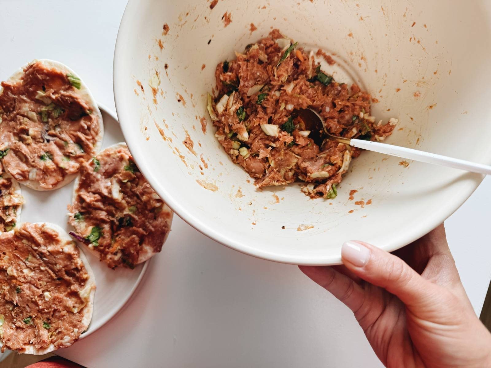 Spreading egg roll filling on flour tortillas.