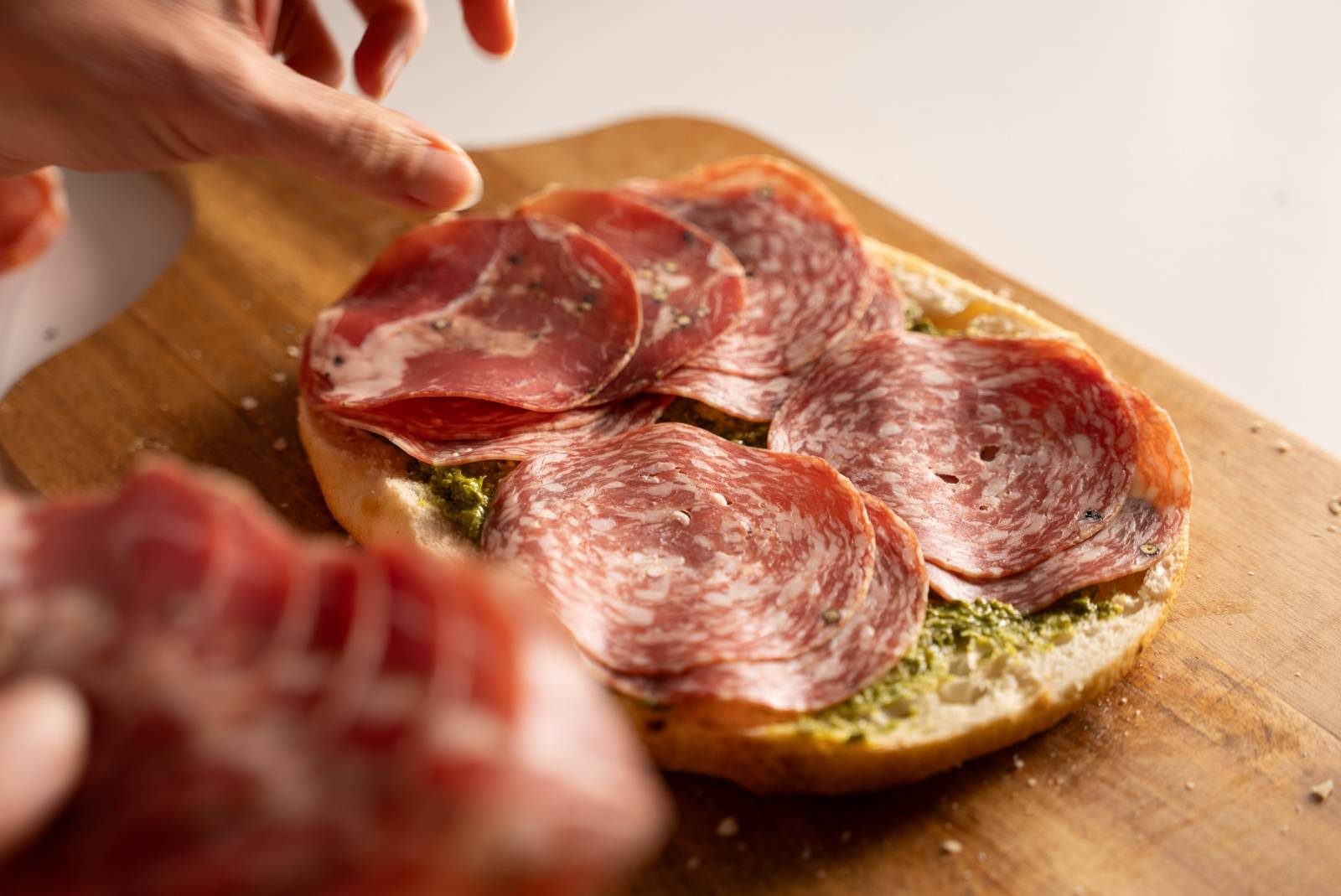 Layering meat on grinder sandwich.