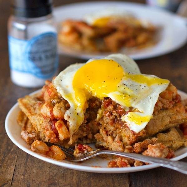 Chili and cornbread waffle stacks on a plate with a fork.