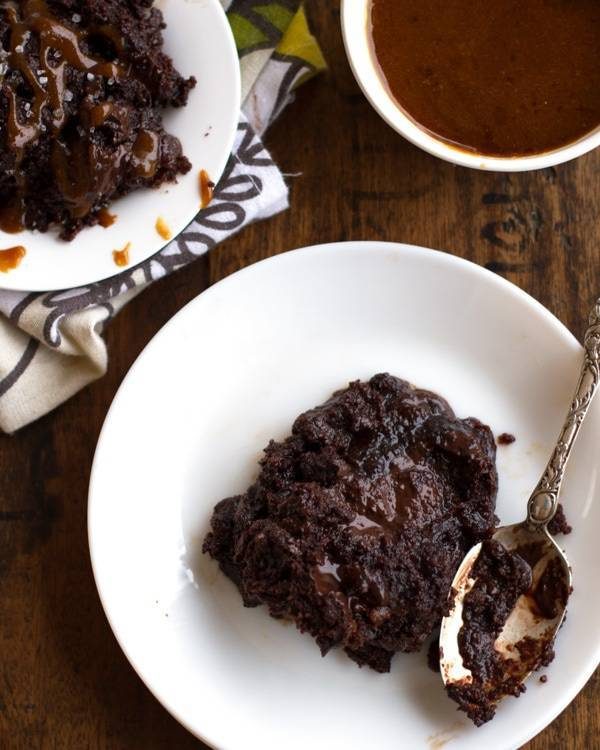 Chocolate caramel cake on a white plate.