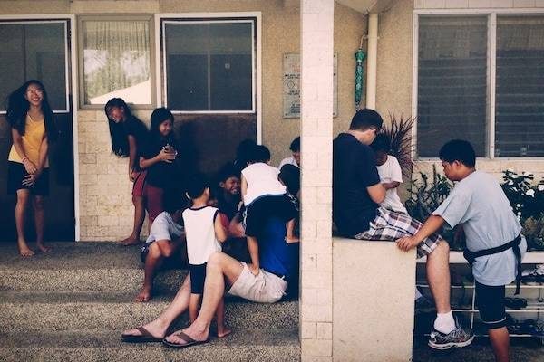 Children sitting near a building.
