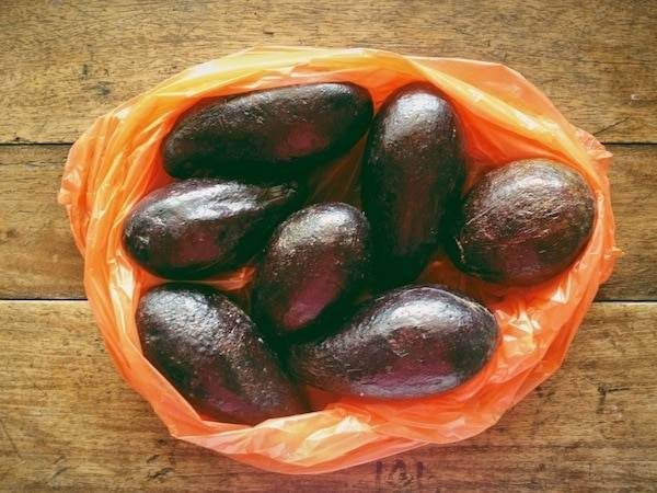 Avocados in an orange plastic bag.
