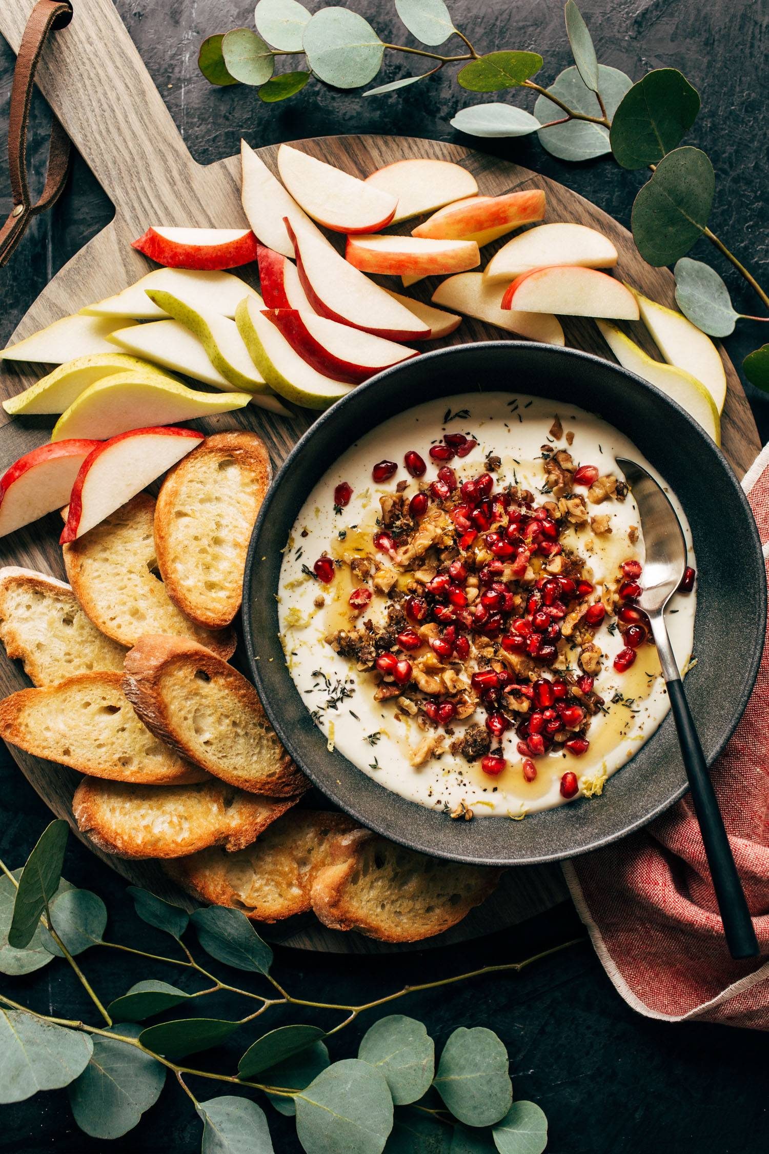 Baked feta topped with pomegranate with apples and sliced baguette.