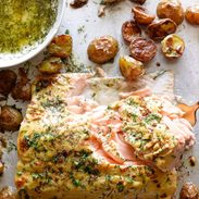 Salmon and potatoes on a sheet pan covered in dill.