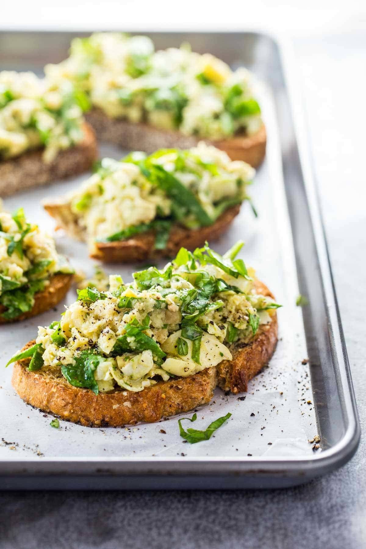 White Bean Artichoke Basil Toasts on a sheet pan.